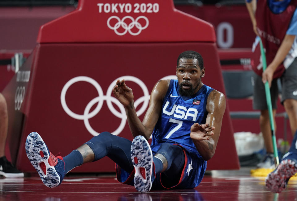 United States' Kevin Durant (7) reacts after falling on the court in an attempt to take control of the ball during men's basketball quarterfinal game against Spain at the 2020 Summer Olympics, Tuesday, Aug. 3, 2021, in Saitama, Japan. (AP Photo/Charlie Neibergall)