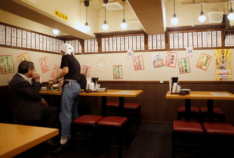 FILE PHOTO: Office worker is seen at "Ikken me sakaba", a discount izakaya bar offering cheap food and drinks, in Tokyo