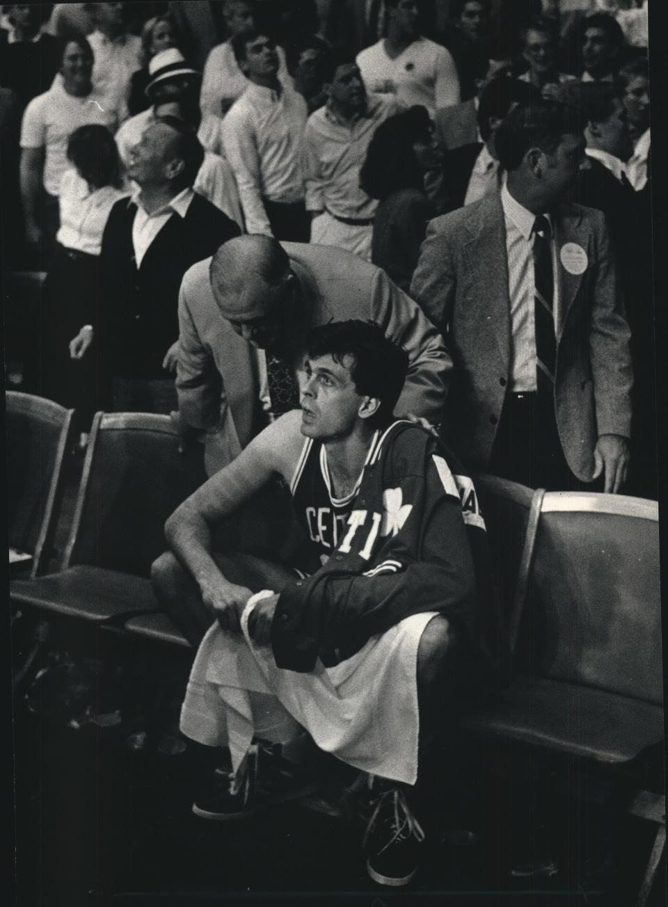 A security guard speaks to Boston's Kevin McHale moments after McHale confronted a fan behind the Celtics bench in the 1987 playoff series at the Milwaukee Arena.