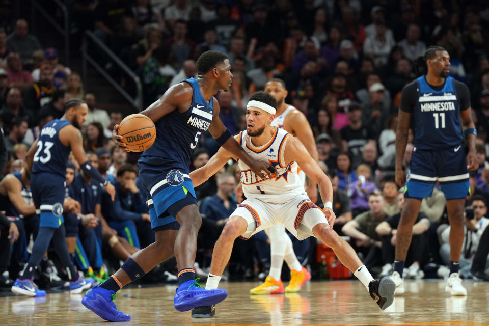 Phoenix Suns guard Devin Booker (1) guards Minnesota Timberwolves guard Anthony Edwards (5) during the second half at Footprint Center in Phoenix on April 5, 2024.