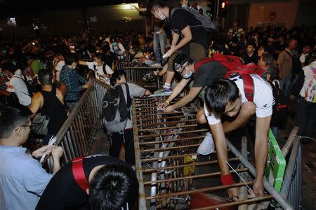 Pro-democracy protesters set up new barricades after riot police retreated from a main road at Mong Kok shopping district in Hong Kong early October 18, 2014. REUTERS/Liau Chung-ren