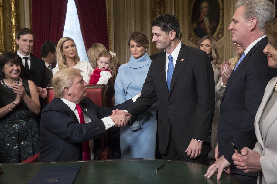 President Donald Trump turns to House Speaker Paul Ryan as he is joined by the Congressional leadership and his family as he formally signs his cabinet nominations into law, in the President's Room of the Senate, at the Capitol in Washington, Friday, Jan. 20, 2017. (AP Photo/J. Scott Applewhite, Pool)