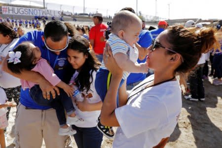 Marcelino Pizarro greets his daughter, Denisse, and for the first time granddaughter Aitana, as his daughter, Fatima Paola, holds her baby brother, Matias, during a greeting for family members from both sides of the border during the