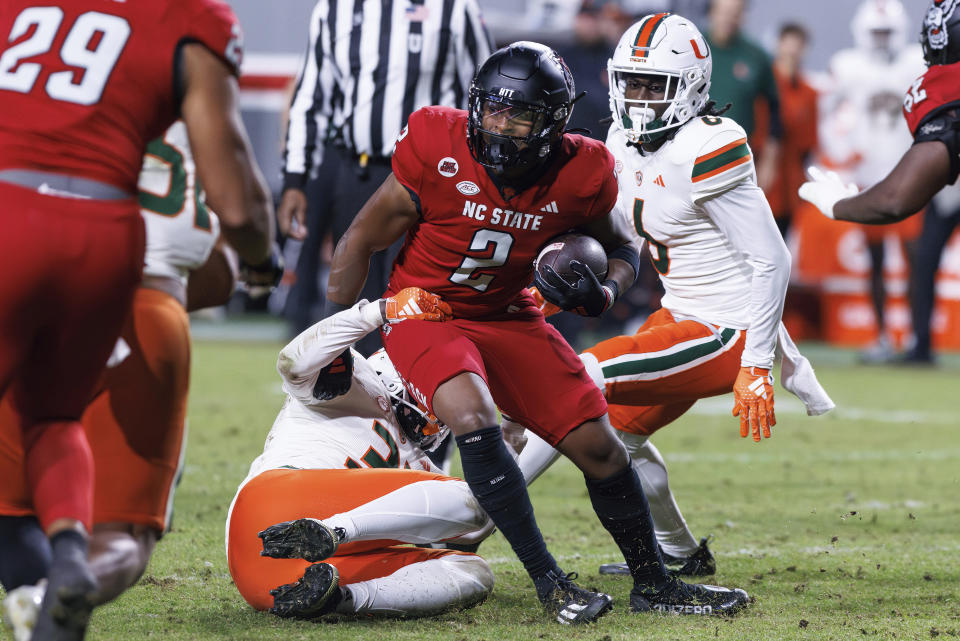 North Carolina State's Michael Allen (2) is tackled by Miami's Wesley Bissainthe (31) during the second half of an NCAA college football game in Raleigh, N.C., Saturday, Nov. 4, 2023. (AP Photo/Ben McKeown)