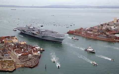 A flotilla of craft follow HMS Queen Elizabeth as she sails into Portsmouth Harbour - Credit: Gareth Fuller/PA