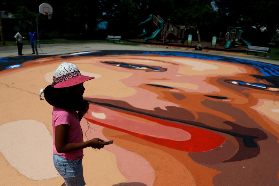 Saniyah Womack, 9, walks on a ground mural depicting a portrait of Breonna Taylor at Chambers Park, Monday, July 6, 2020, in Annapolis, Md. The mural honors Taylor, a 26-year old Black woman who was fatally shot by police in her Louisville, Kentucky, apartment. The artwork was a team effort by the Banneker-Douglass Museum, the Maryland Commission on African American History and Culture, and Future History Now, a youth organization that focuses on mural projects. (AP Photo/Julio Cortez)