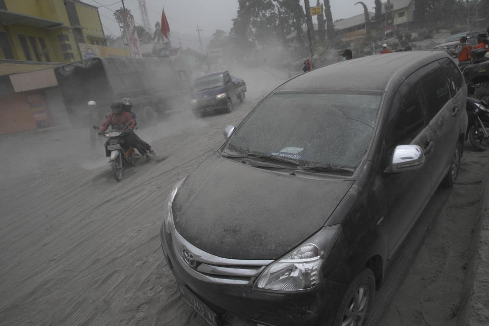 Vehicles and a street are covered with volcanic ash from an eruption of Mount Kelud in Malang, East Java, Indonesia, Saturday, Feb. 15, 2014. The powerful volcanic eruption on Indonesia's most populous island blasted ash and debris 18 kilometers (12 miles) into the air Friday, forcing authorities to evacuate more than 100,000 and close seven airports. (AP Photo/Trisnadi)