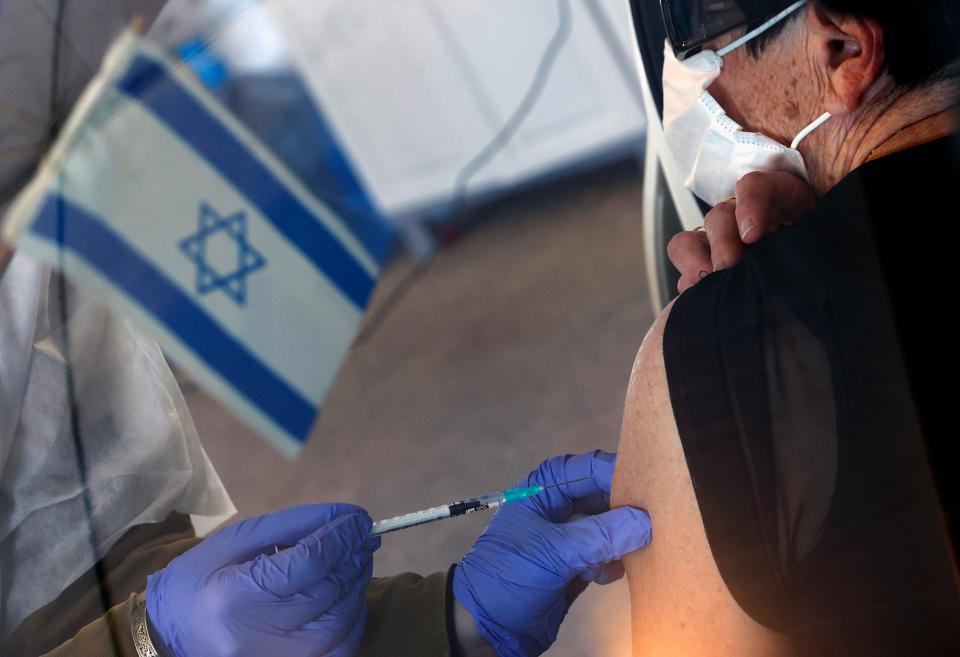 An Israeli senior citizen receives her second Pfizer Covid vaccine at the Maccabi Health Services drive-in vaccination center, in the northern coastal city of Haifa (AFP via Getty Images)