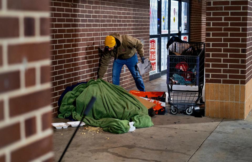 Cale Powers leaves a note with a person outside a store in northwest Oklahoma City on Jan. 26 during the Homeless Alliance's 2023 Point in Time count of the homeless population.