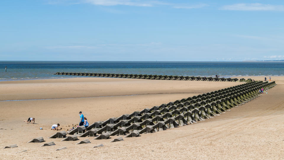 Modern sea defences on Wallasey beach seen in July 2020 (near Liverpool, England) as the tide rushes in.