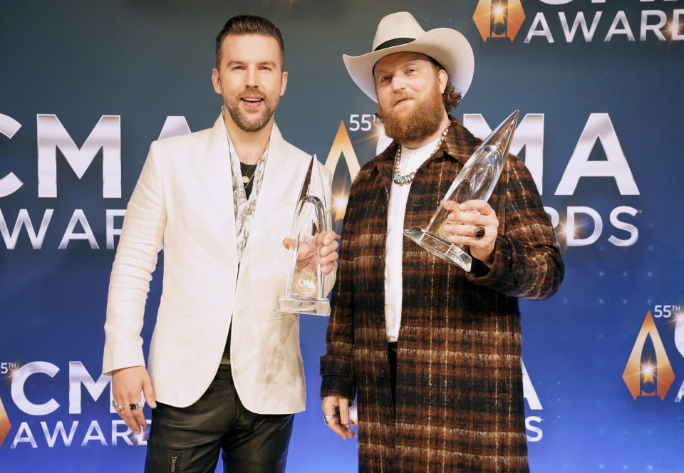 T.J. Osborne, left, and John Osborne, of Brothers Osborne, pose in the press room with the award for best vocal duo of the year at the 55th annual CMA Awards on Wednesday, Nov. 10, 2021, at the Bridgestone Arena in Nashville, Tenn. (AP Photo/Ed Rode) - Credit: AP