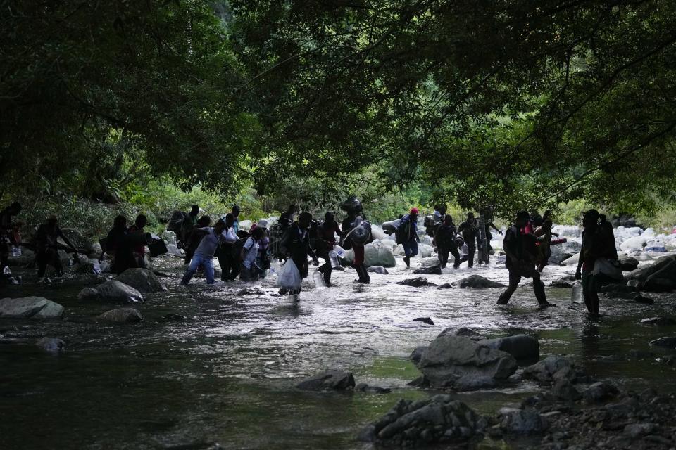 Migrants cross the Acandi River as they continue on their trek north, in Acandi, Colombia, Wednesday, Sept. 15, 2021. The migrants, following a well-beaten, multi-nation journey towards the U.S., will continue their journey through the jungle known as the Darien Gap. (AP Photo/Fernando Vergara)