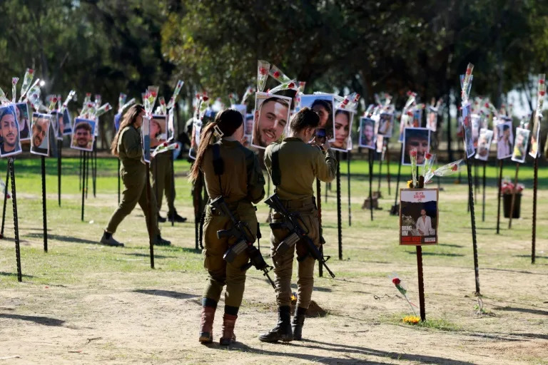 Israeli soldiers pay their respects to those killed or taken hostage by Hamas at the Supernova music festival (Menahem KAHANA)
