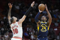 Indiana Pacers guard Buddy Hield (24) takes a shot against Miami Heat forward Caleb Martin (16) during the first half of an NBA basketball game, Wednesday, Feb. 8, 2023, in Miami. (AP Photo/Wilfredo Lee)