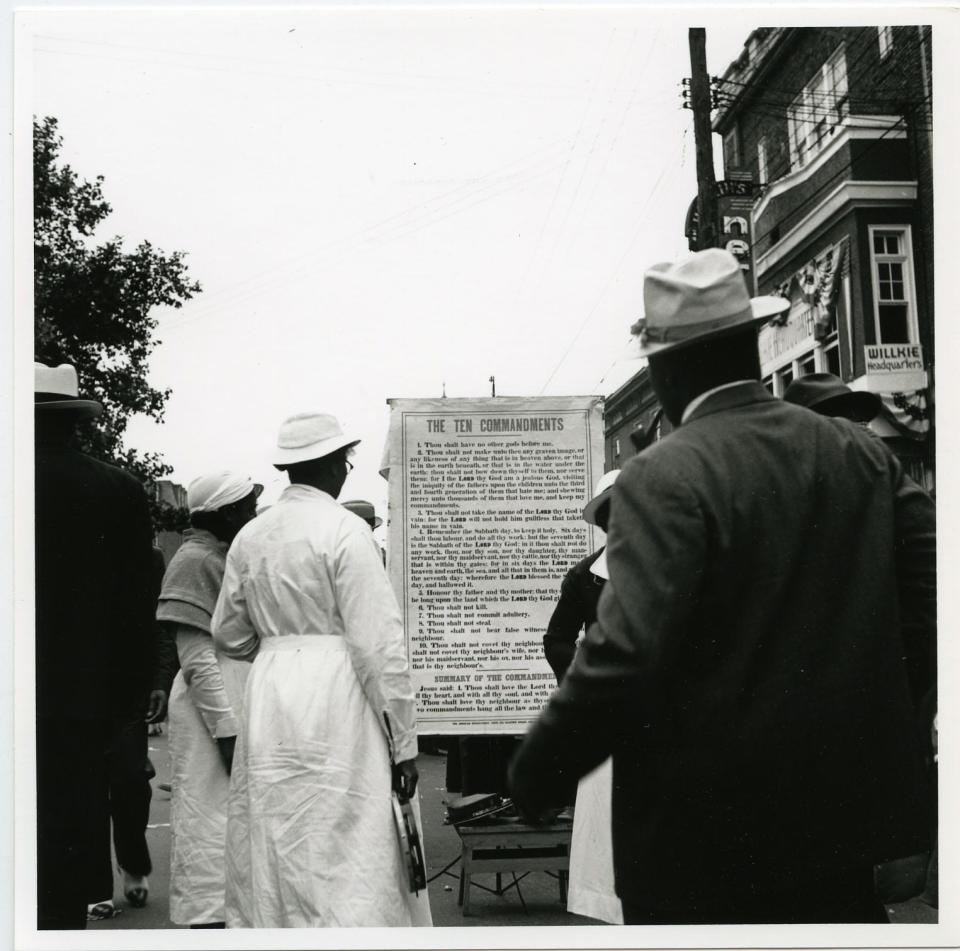 People gather around a board listing the 10 commandments during the 1939 Big Quarterly in Wilming
ton, Delaware.