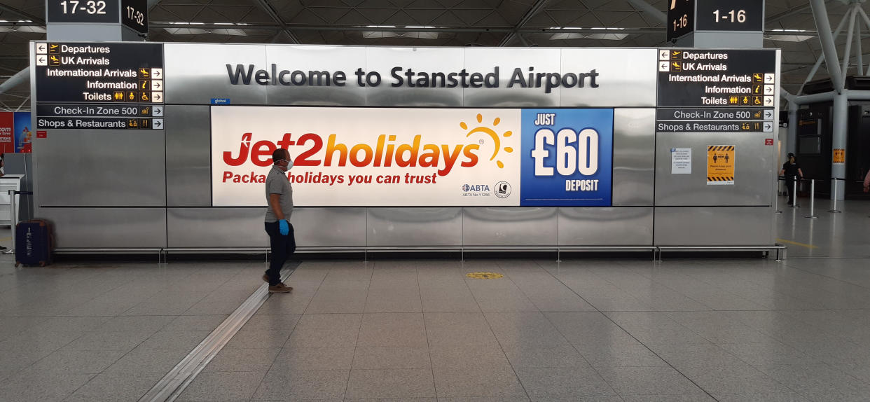 A person in a mask and gloves at Stansted Airport, Essex, as new quarantine rules for travellers arriving in the UK are to be set out by Home Secretary Priti Patel. The plans, due to come into force on June 8, will see people arriving in the UK told to isolate for 14 days to prevent coronavirus cases being introduced from overseas. (Photo by Nick Ansell/PA Images via Getty Images)