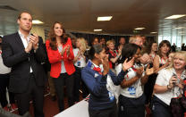 Kate celebrates the GB cycling team after a gold win in team pursuit. She wears a vibrant red blazer, polka-dot blouse and black skinny jeans. (Getty Images)