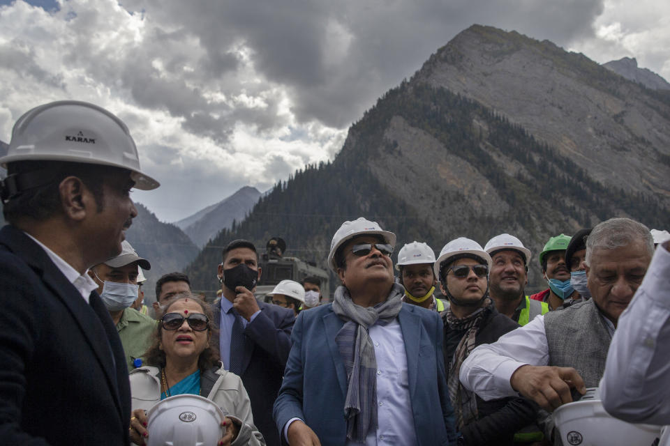 Indian Transport Minister Nitin Gadkari, center, accompanied by his wife looks at the under construction Zojila tunnel in Baltaal, northeast of Srinagar, Indian controlled Kashmir, Tuesday, Sept. 28, 2021. High in a rocky Himalayan mountain range, hundreds of people are working on an ambitious project to drill tunnels and construct bridges to connect the Kashmir Valley with Ladakh, a cold-desert region isolated half the year because of massive snowfall. The $932 million project’s last tunnel, about 14 kilometers (9 miles) long, will bypass the challenging Zojila pass and connect Sonamarg with Ladakh. Officials say it will be India’s longest and highest tunnel at 11,500 feet (3,485 meters). (AP Photo/Dar Yasin)