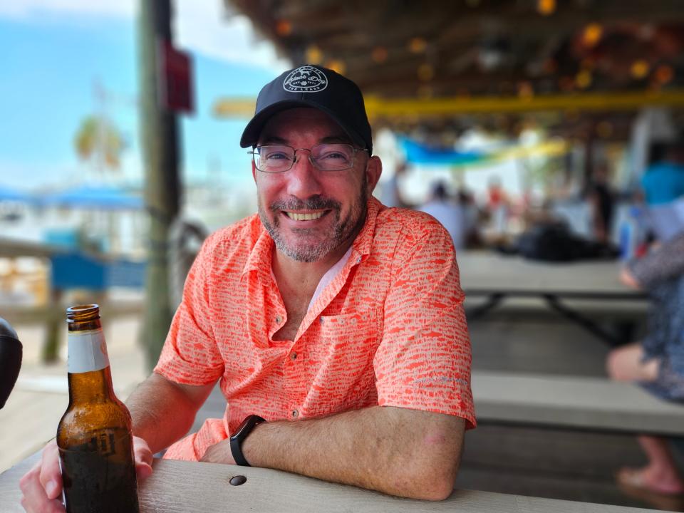 Wade Tatangelo enjoys a cold beer while waiting for his food at Star Fish Company, overlooking north Sarasota Bay in the commercial fishing village of Cortez on July 29, 2023.