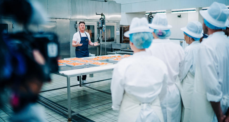 Gordon Ramsay and contestants in the kitchen with salmon fillets.