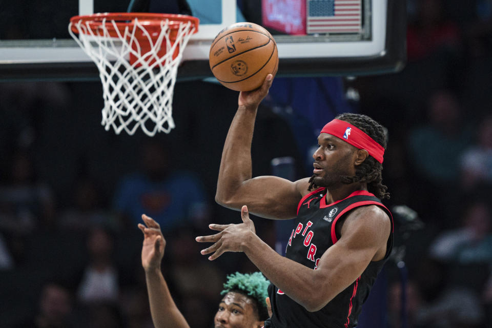 Toronto Raptors forward Precious Achiuwa passes the ball during the first half of the team's NBA basketball game against the Charlotte Hornets in Charlotte, N.C., Tuesday, April 4, 2023. (AP Photo/Jacob Kupferman)