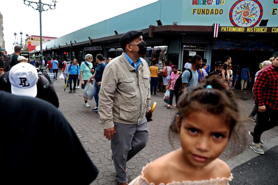 A man walks down a crowded street.