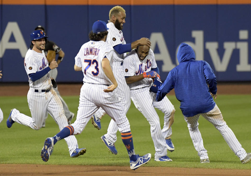New York Mets' Jack Reinheimer, left, Daniel Zamora (73) and Amed Rosario congratulate Austin Jackson after Jackson hit a home run to defeat the Miami Marlins 1-0 during the 13th inning of a baseball game Saturday, Sept. 29, 2018, in New York. (AP Photo/Bill Kostroun)