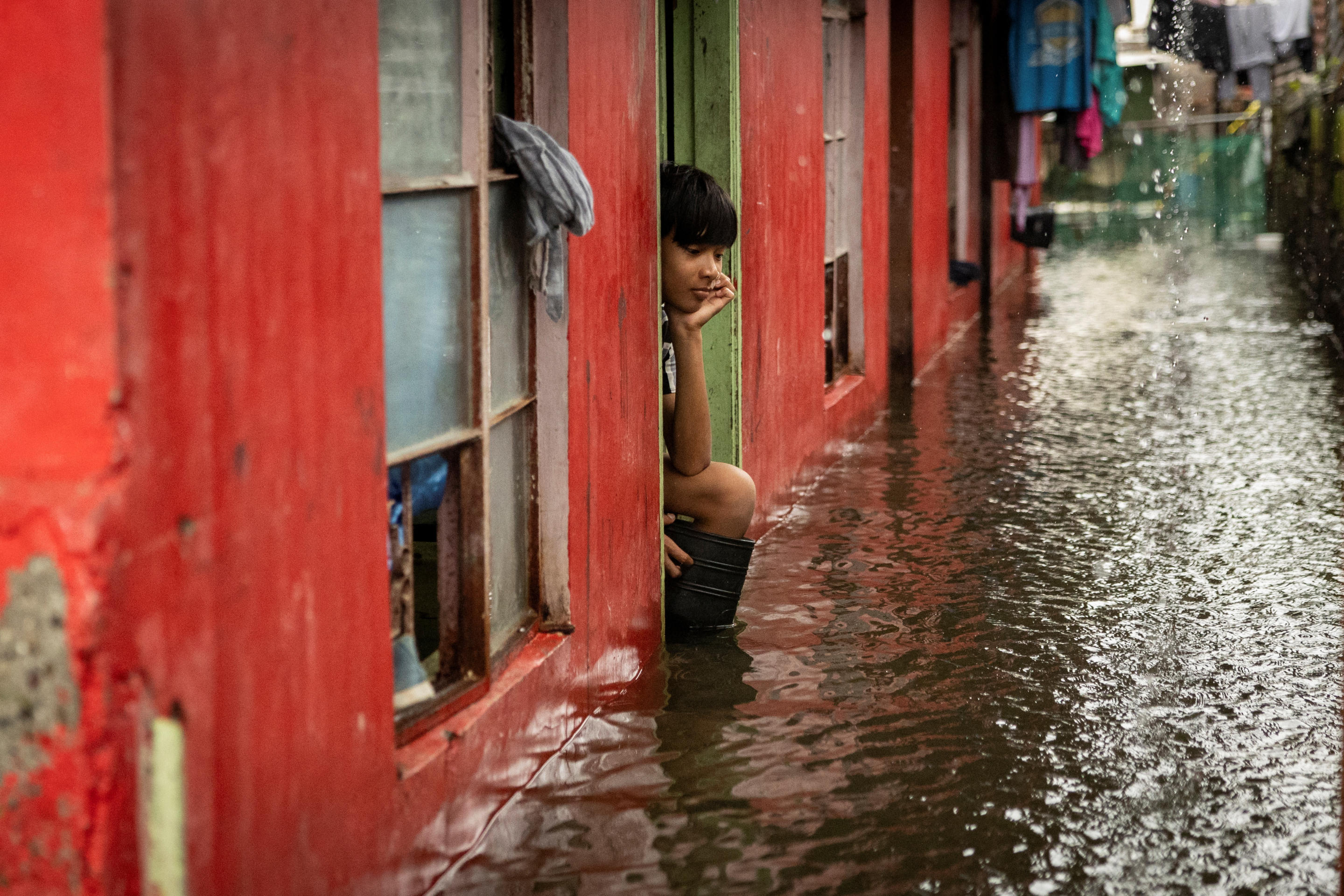 A child looks out from their flooded home amid heavy rains brought by Tropical Storm Yagi, locally known as Enteng in Macabebe, Pampanga, Philippines, September 5, 2024. (Eloisa Lopez/Reuters)