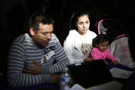 Enrique Gonzalez, 22, (L-R), Janet Regalado, 21, and their nine-month-old daughter Kayleen Gonzalez pose for a photo after signing up for health insurance at an enrolment event in Commerce, California March 31, 2014. REUTERS/Lucy Nicholson