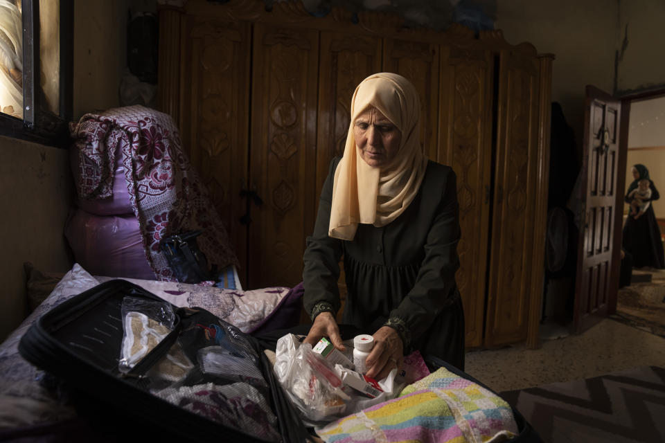 Huda Zaqqout, a Palestinian woman preparing for the Hajj, inspects her medications as she prepares her suitcase at her home in Gaza City Wednesday, May 31, 2023. (AP Photo/Fatima Shbair)