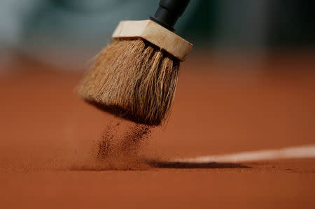 FILE PHOTO: A close up shows a worker's brush sweeping over a line of a court during a women's singles match between Jelena Jankovic of Serbia and Sara Errani of Italy at the French Open tennis tournament at the Roland Garros stadium in Paris, France June 2, 2014. REUTERS/Gonzalo Fuentes/File Photo