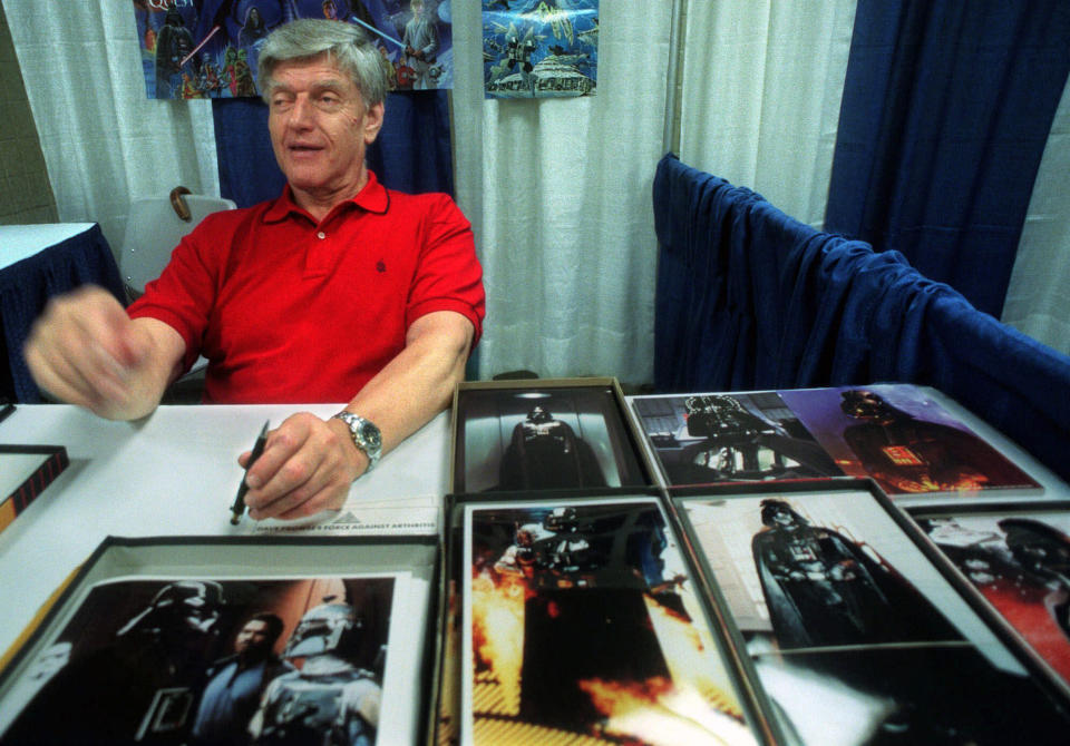 FILE - In this file photo dated Friday, May 7, 1999, Dave Prowse, the original Darth Vader from the "Star Wars Trilogy," poses during the New York Comic and Fantasy Creators Convention. The British actor, Prowse who played Darth Vader in the original Star Wars trilogy, has died aged 85 on Saturday, according to an announcement by his agent Sunday Nov. 29, 2020. (AP Photo/Lynsey Addario, FILE)