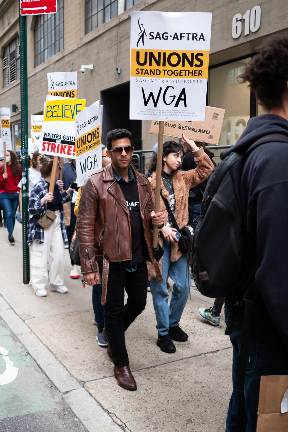 man at WGA protest wearing brown leather jacket and black pants