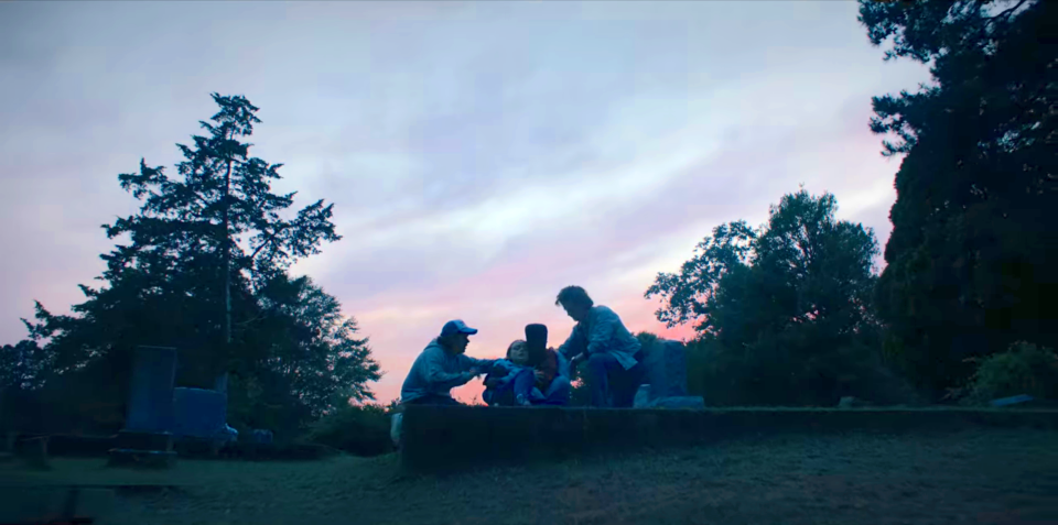 Four people sitting in a field