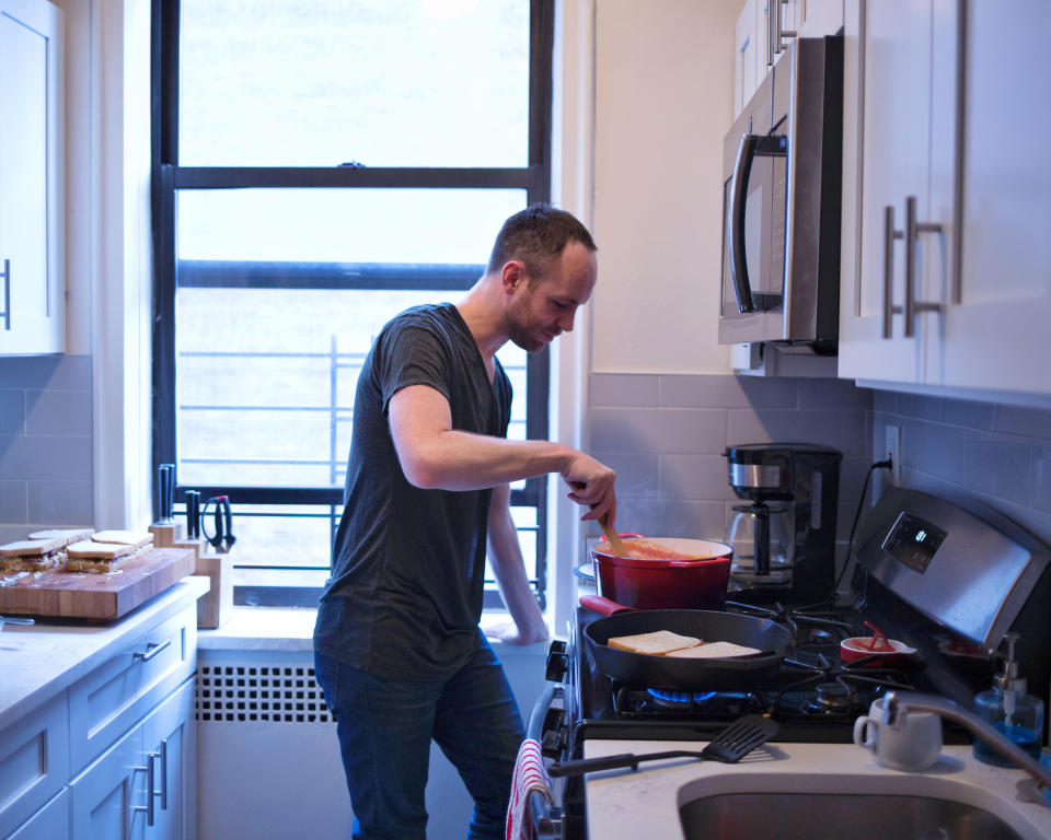 This is me, cooking some classic comfort food —  tomato soup and grilled cheese — in my Washington Heights kitchen.  (Trent Pheifer)