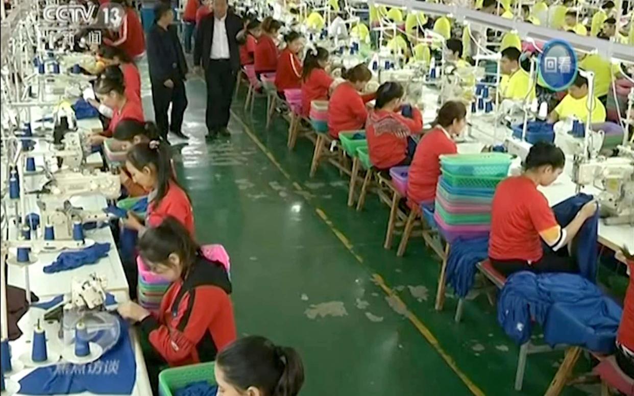 Undated video footage shows Muslim trainees work in a garment factory at the Hotan Vocational Education and Training Centre in Hotan, Xinjiang - CCTV via AP Video