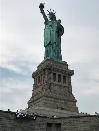 The group Rise and Resist stage a protest at the Statue of Liberty in New York, U.S. July 4, 2018 in this picture obtained from social media. Rise and Resist/via REUTERS