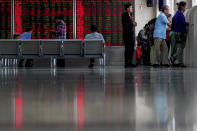 Chinese investors check stock prices at a brokerage house in Beijing, Thursday, Sept. 19, 2019. Shares were mixed in Asia on Thursday, with Tokyo and Sydney logging modest gains after the Federal Reserve cut its benchmark interest rate for a second time this year, citing slowing global economic growth and uncertainty over U.S. trade conflicts. (AP Photo/Andy Wong)