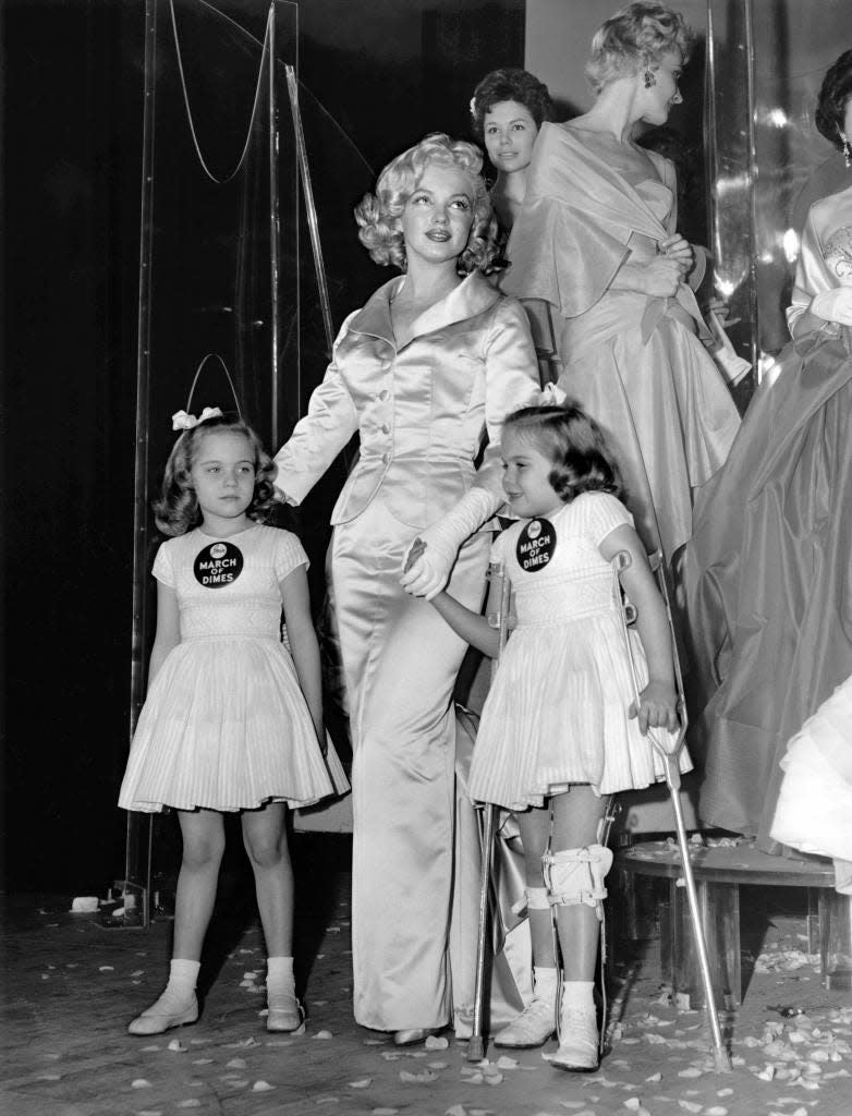 Actress Marilyn Monroe with 1958 March of Dimes poster children Linda and Sandra Solomon, and the 14th annual March of Dimes fashion show in 1958.