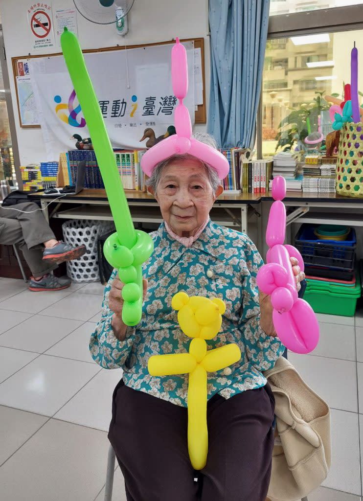 九十五歲的阿嬤蘇葉金蕊自己動手捏塑汽球，玩得很開心。（記者陳俊文攝）