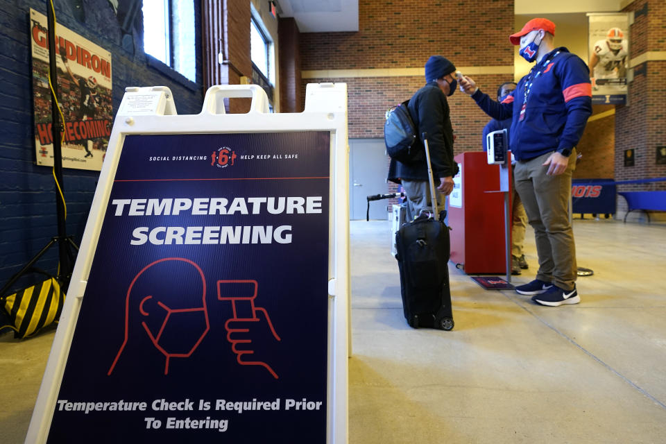 A photographer has his temperature checked as he arrives for an NCAA college football game between Illinois and Purdue Saturday, Oct. 31, 2020, in Champaign, Ill. (AP Photo/Charles Rex Arbogast)