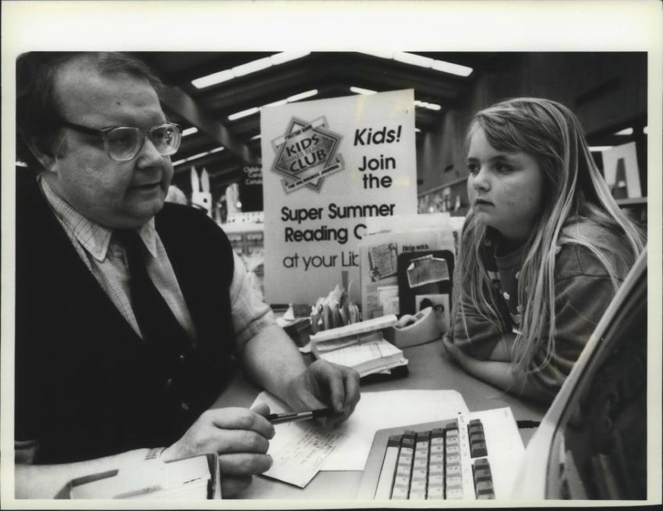 Third grader Amanda Foster listens as children's librarian Neil Kaluzny explains the Kids Summer Reading Club at the Tippecanoe Library in 1993. The club gives young readers a variety of incentives to reach their personal reading goals.