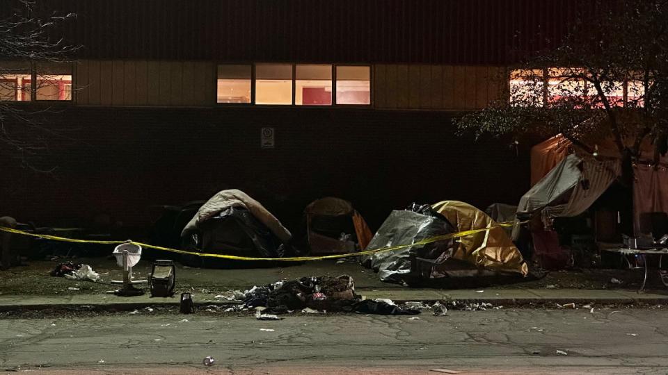 Tents behind police tape at the homeless encampment near Robert-Gertin Centre in Gatineau, Que., on Nov. 16, 2023, after a man was discovered dead inside his tent.