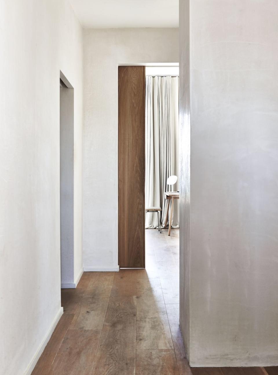 a hallway with a chair and a lamp