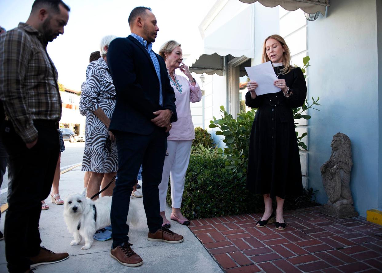 The Rev. Susan R. Beebe reads a Bible passage from the Book of Daniel, about Daniel surviving in the lions' den, during the blessing of a pair of stone lions next to the front door of the Church Mouse in Palm Beach on April 24.