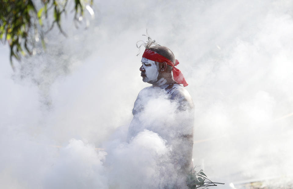 Russell Dawson of the Koomurri Aboriginal Dancers participates in a smoking ceremony during Australia Day ceremonies in Sydney, Tuesday, Jan. 26, 2021. (AP Photo/Rick Rycroft)