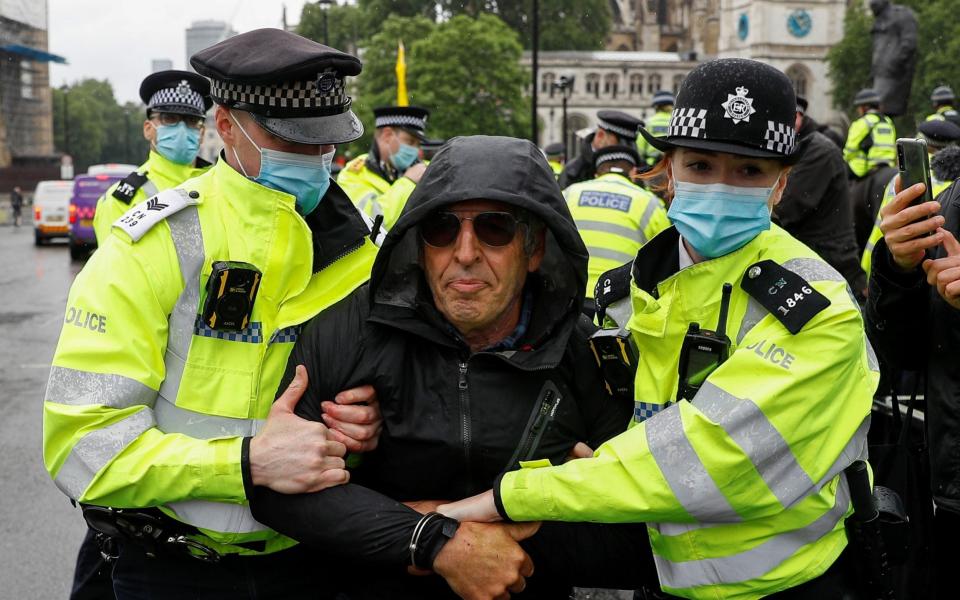 A man is led away by police during an anti-lockdown protest in Westminster on 21 June 2021 - Peter Nicholls/Reuters