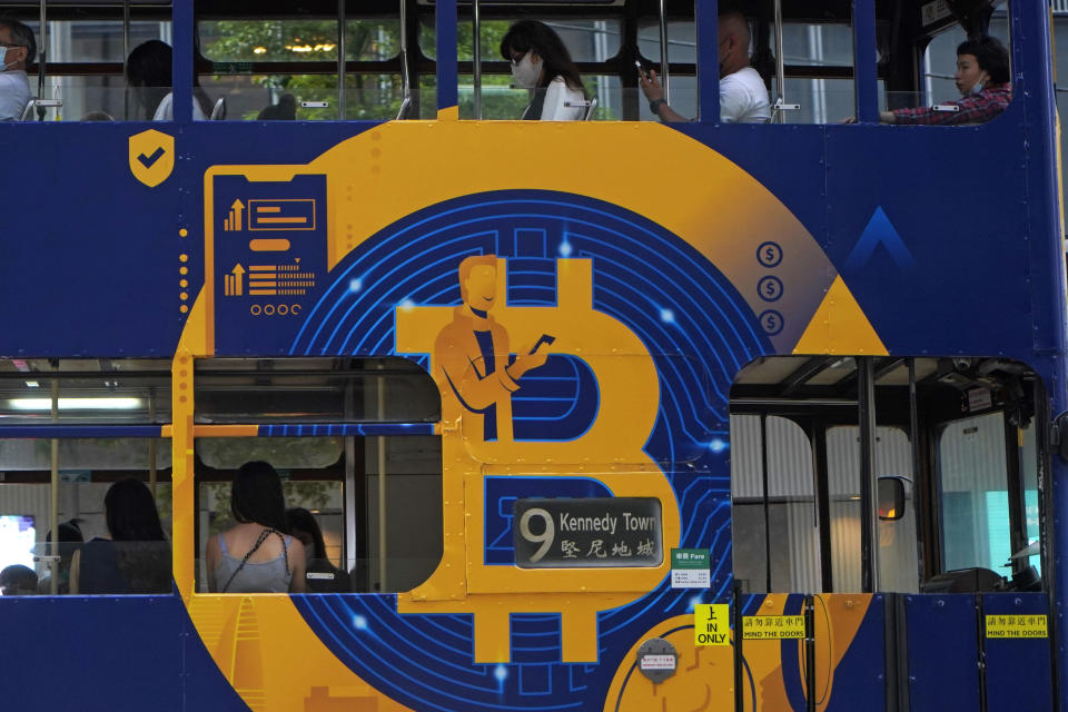 FILE - This May 12, 2021, file photo shows an advertisement for the cryptocurrency Bitcoin displayed on a tram in Hong Kong. Cryptocurrencies have surged to nearly $2.5 trillion in total value, rivaling the size of G7 economies like Canada’s and Italy’s, with more than 200 million users. At that size, it’s simply too large for the financial establishment to ignore. Firms that cater to the world’s wealthiest families are increasingly putting some of their fortunes into crypto. Hedge funds are trading Bitcoin, which has big-name banks starting to offer them services around it. And in the latest milestone for the industry, an easy-to-trade fund tied to Bitcoin began trading on Tuesday, Oct. 19, 2021. (AP Photo/Kin Cheung, File)