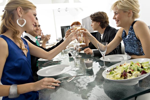 Group of people toasting with champagne at a dinner party