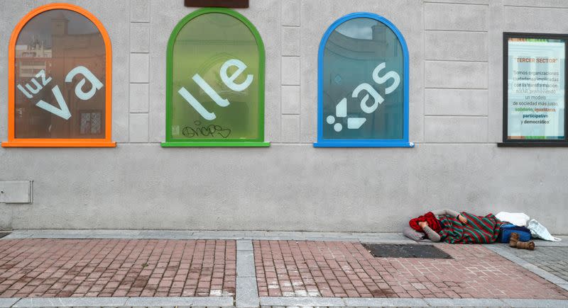 A woman sleeps on the ground at Vallecas neighbourhood in Madrid